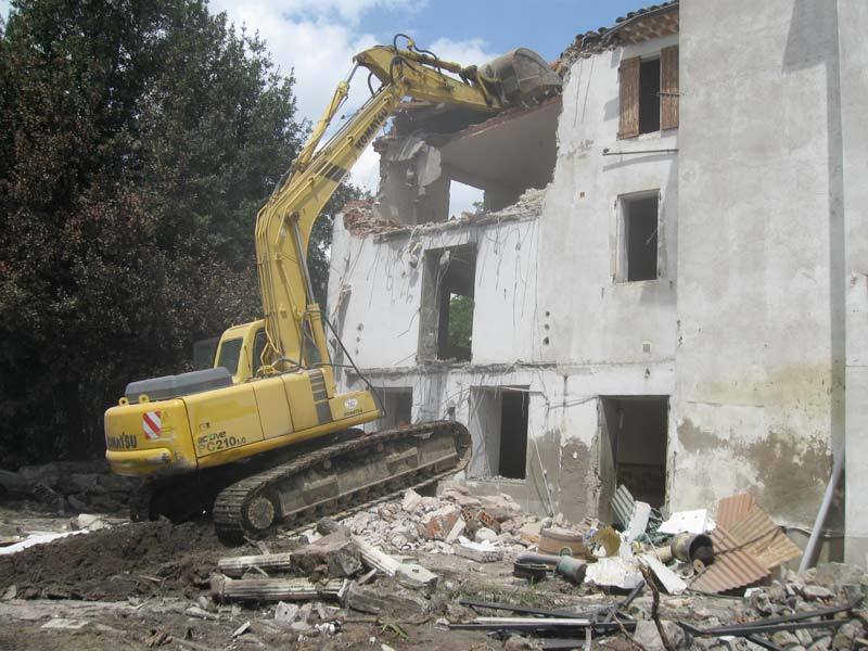 Pelle CAT Jean Roger démolissant une maison de village