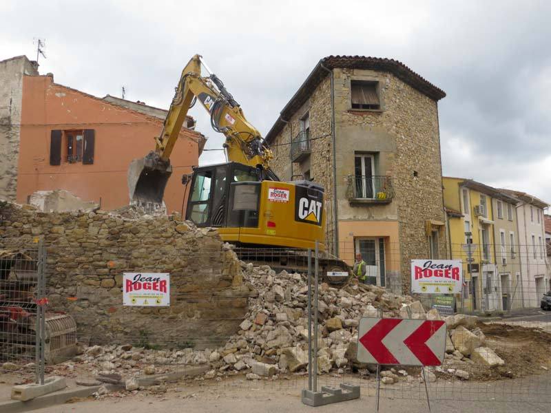 Pelle CAT Jean Roger démolissant un bâtiment en centre-ville