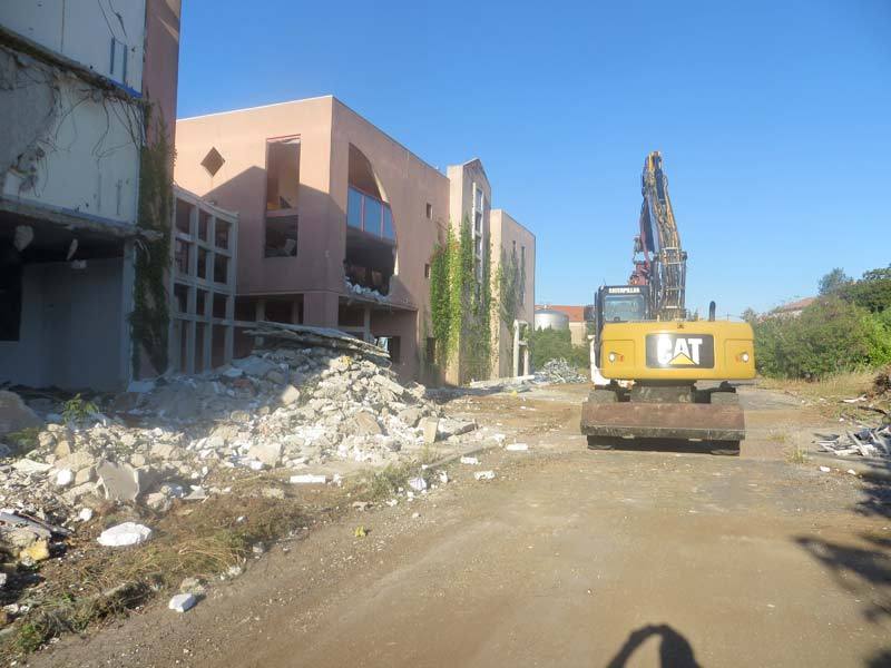 Pelle de démolition en action au pied d'immeubles