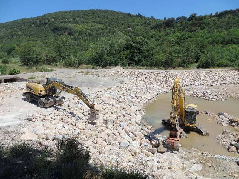 Pelles Jean Roger en enrochement dans le lit d'une rivière